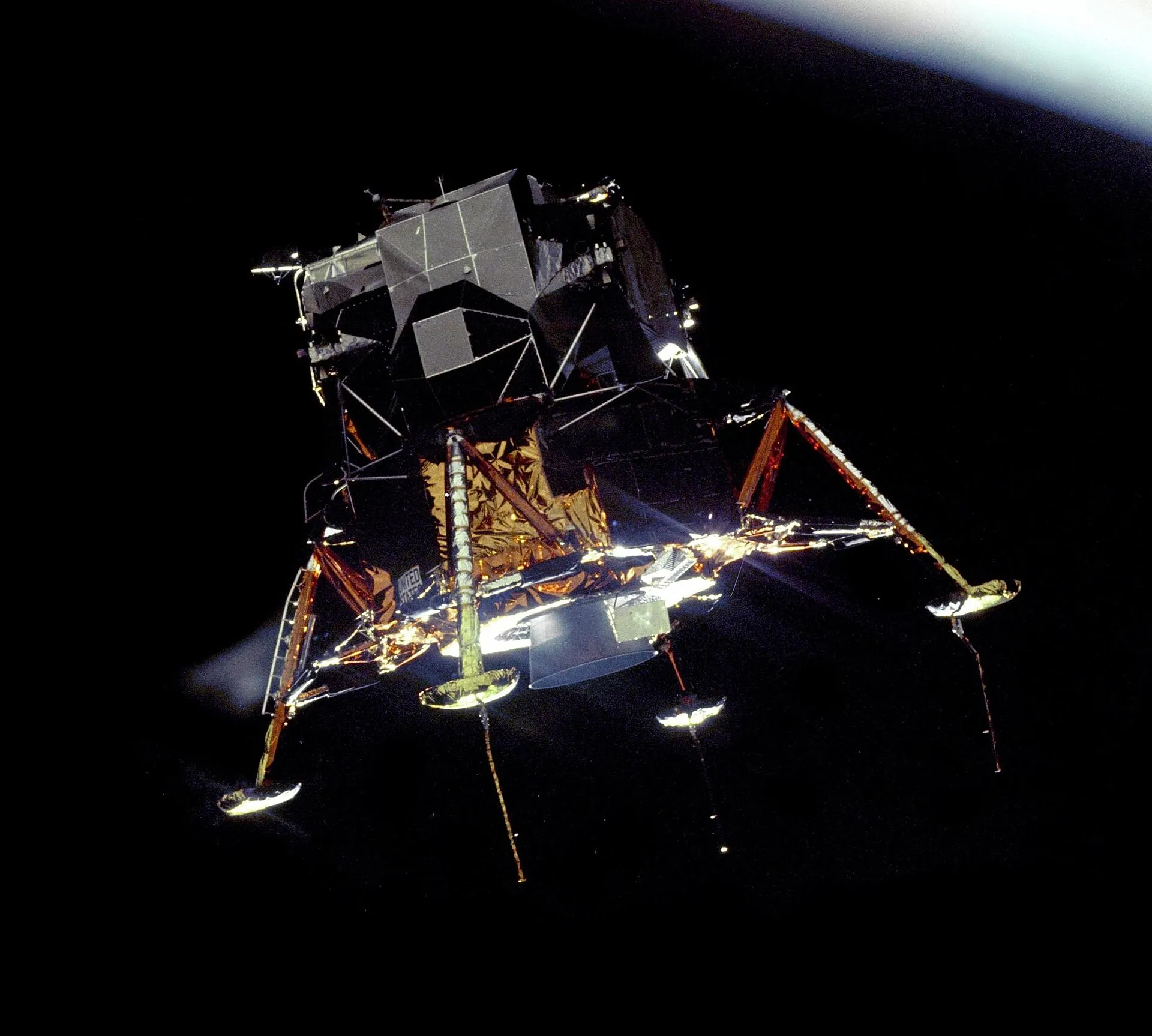 El módulo lunar Eagle, dorado y con las patas desplegadas, en órbita sobre el negro del espacio